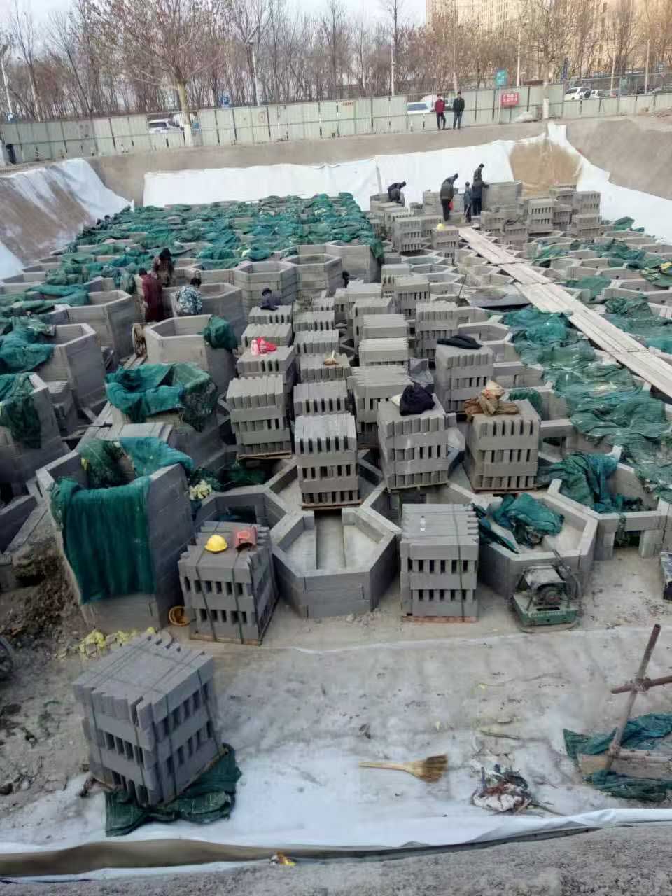 工人在基坑内组装预制六边形混凝土蓄水模块