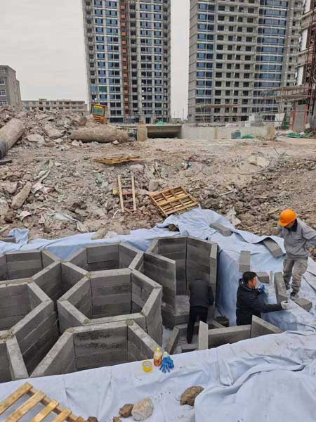 硅砂雨水收集池模块安装现场，工人正在进行拼装作业