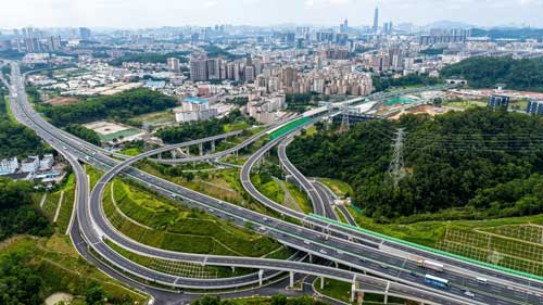 深圳外环高速立交桥全景图，展示现代化立体交通与桥下海绵城市绿化带