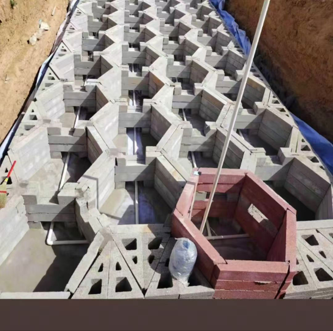 硅砂雨水收集池施工基坑的近景特写，展示了由灰色硅砂板材组装而成的正六边形蜂巢网络