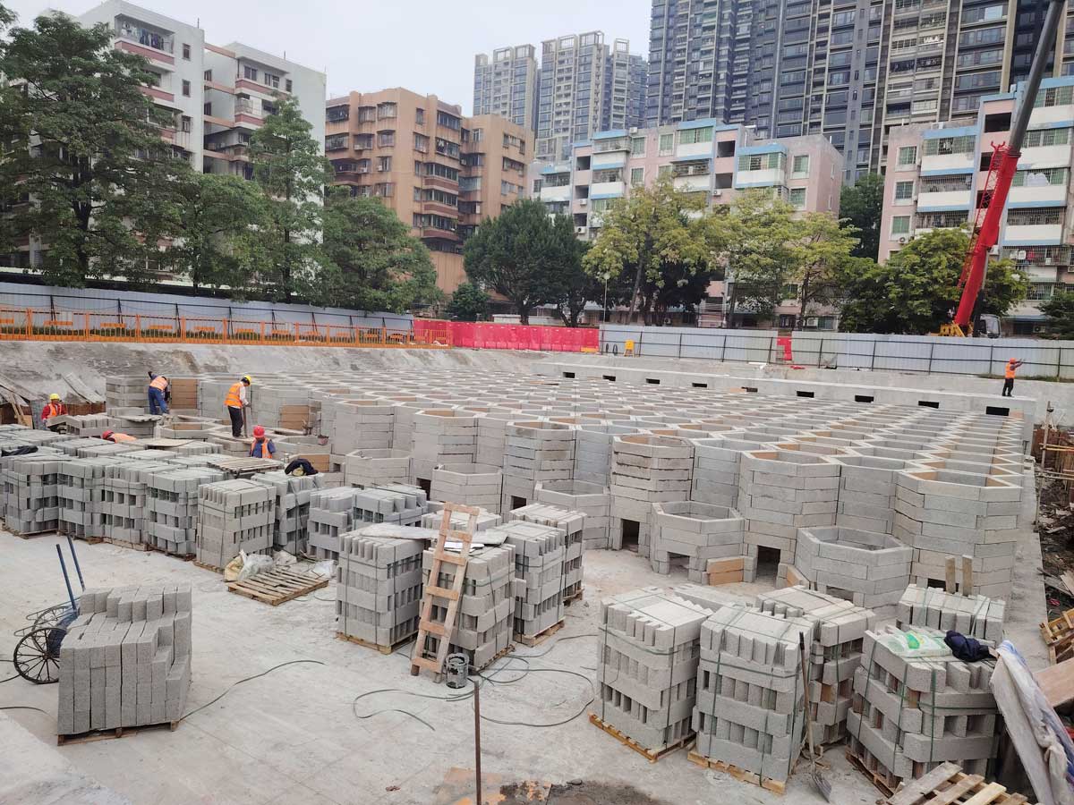 工人们在城市基坑内拼装硅砂模块雨水收集池，助力海绵城市地下蓄水系统建设