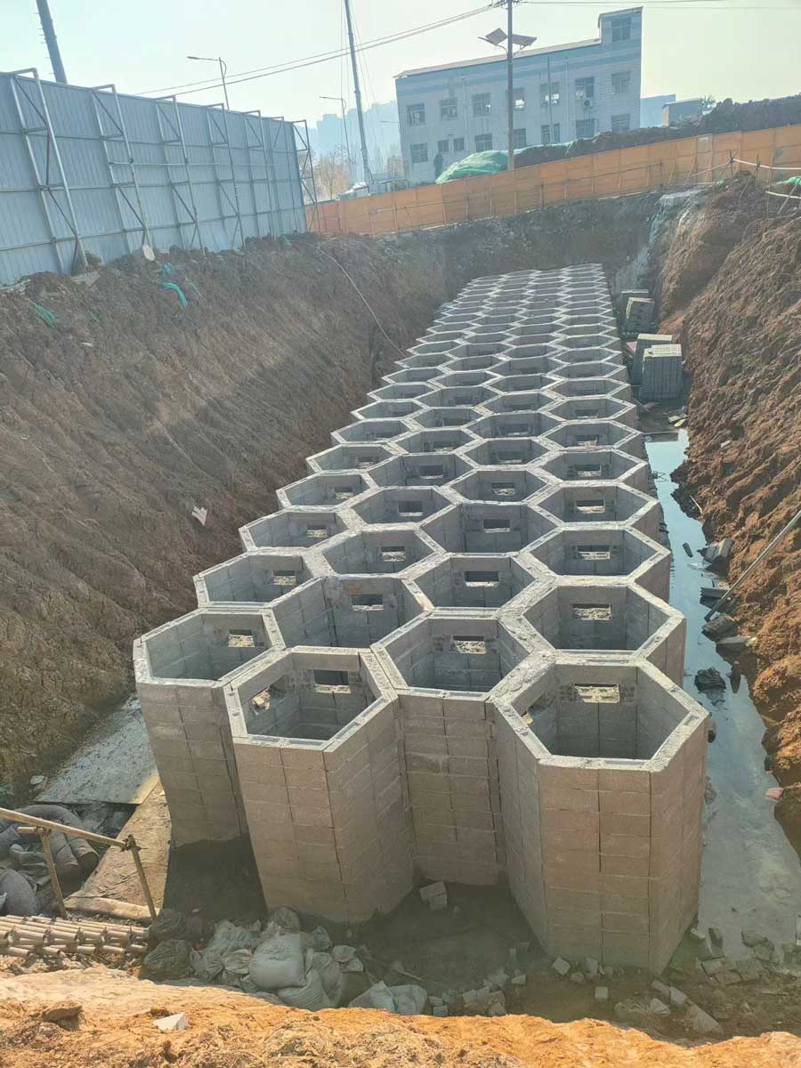 建筑工地深基坑内呈现出多层重叠、整齐划一的正六边形蜂巢状硅砂雨水收集池