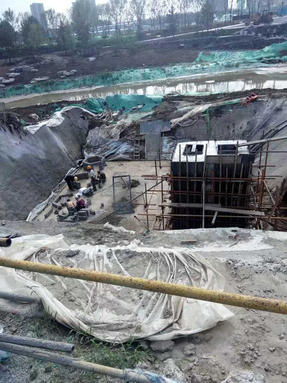 工人们正在进行地下现浇混凝土箱体脚手架搭设以及硅砂蜂巢雨水蓄水池初期底座铺设的协同施工 工人们正在进行地下现浇混凝土箱体脚手架搭设以及硅砂蜂巢雨水蓄水池初期底座铺设的协同施工