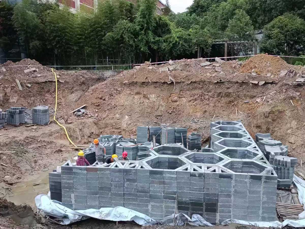 工地深基坑内,建筑工人正在基坑内拼装垒筑蜂巢状硅砂雨水收集池模块 工地深基坑内,建筑工人正在基坑内拼装垒筑蜂巢状硅砂雨水收集池模块
