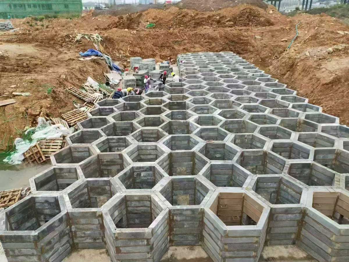 户外建筑工地的基坑内,由大量灰色正六边形硅砂模块拼装而成的蜂巢状雨水收集池结构 户外建筑工地的基坑内,由大量灰色正六边形硅砂模块拼装而成的蜂巢状雨水收集池结构