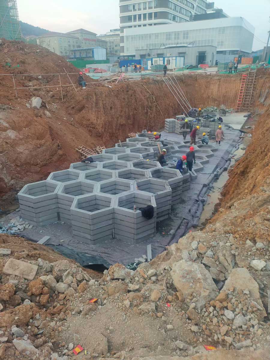 建筑工地深基坑内多名工人正在合力拼装组装的蜂巢状地下硅砂雨水收集池 建筑工地深基坑内多名工人正在合力拼装组装的蜂巢状地下硅砂雨水收集池